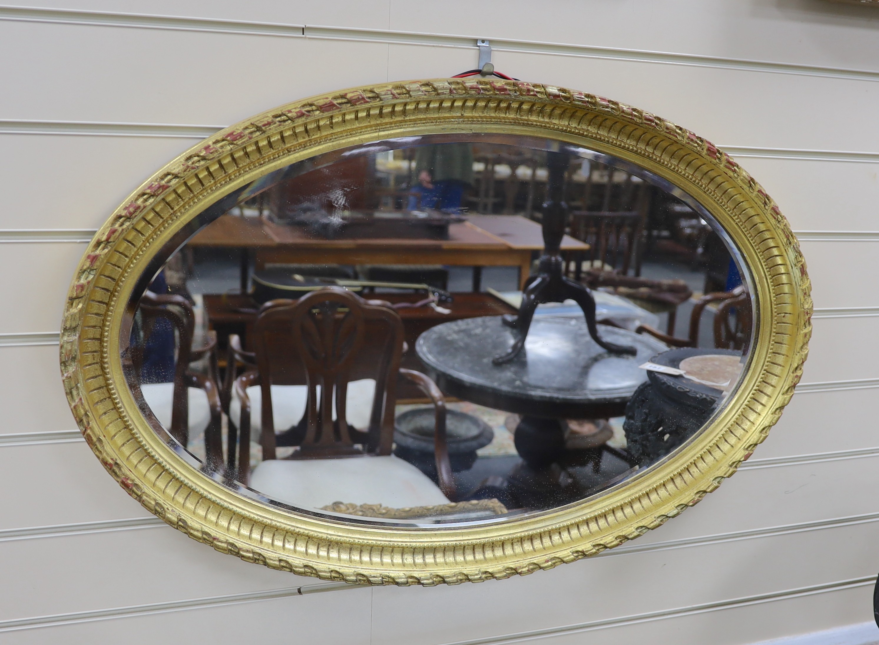 An oval moulded gilt wall mirror width 86cm, height 56cm.
